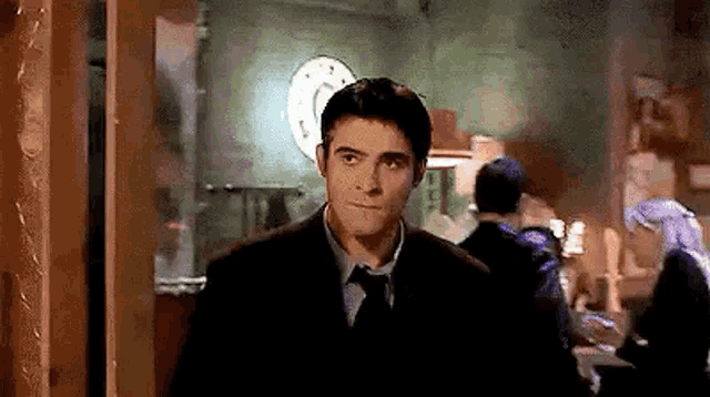 a man in a suit and tie is standing in a doorway in a room .