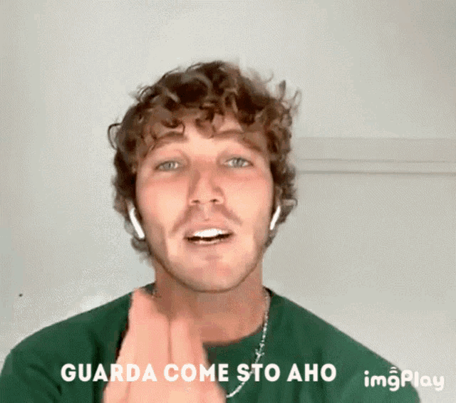 a man with curly hair is wearing headphones and says guarda come sto aho