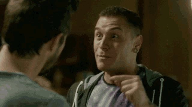 two men are talking to each other in a dark room .