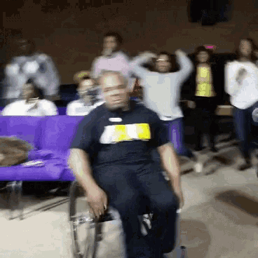 a man in a wheelchair is wearing a shirt that says ' a ' on it