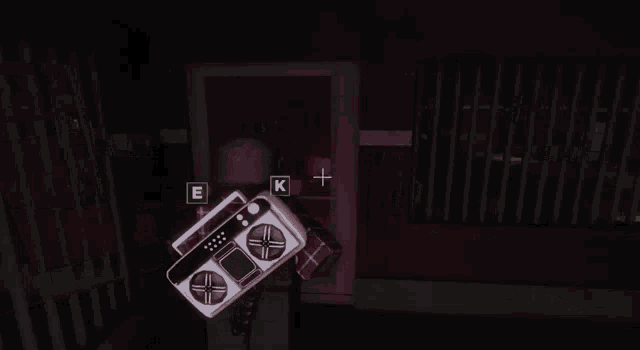 a person holding a boombox in a dark room with the letter k on it