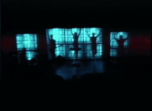 a silhouette of people standing in front of a window