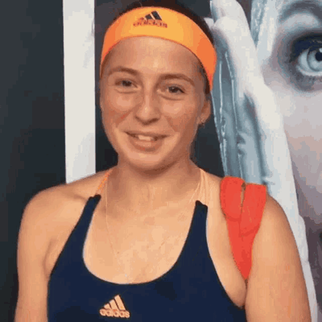 a woman wearing an orange headband that says adidas