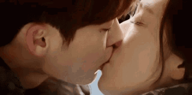 a man and a woman are kissing each other on the cheek .