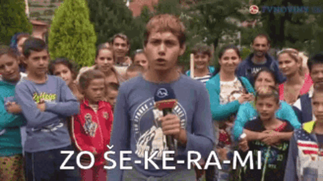 a man holding a microphone in front of a crowd with the words zo se-ke-ra-mi written on the bottom
