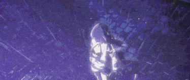a woman in a white dress is standing on a brick floor in a dark room .