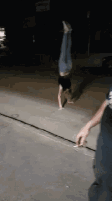a person is doing a handstand on the side of the road