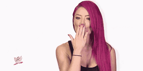a woman with long pink hair is blowing a kiss .