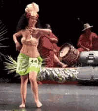 a woman is dancing on a stage in front of a drummer