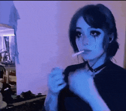 a woman with blue eyes is smoking a cigarette in a room .