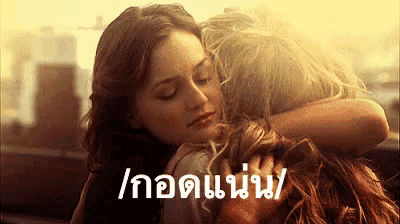 a woman is hugging another woman with a foreign language written below her