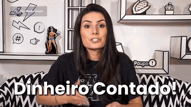 a woman is sitting on a couch with the words dinheiro contado written on the wall behind her