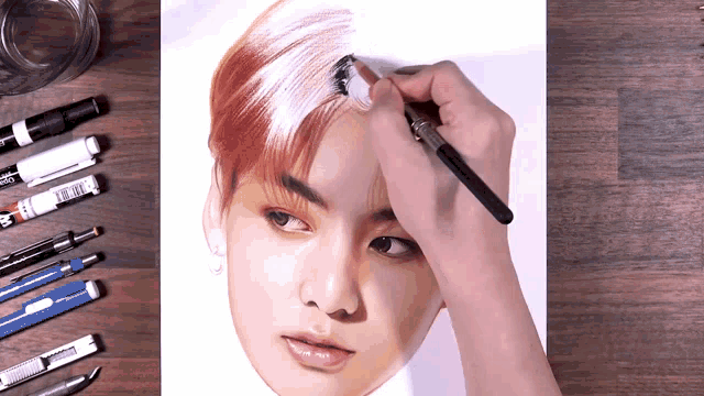 a drawing of a man 's face is being painted with a brush by a person