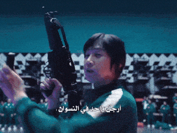 a man is holding a gun with arabic writing on the bottom