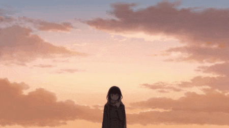 a girl is standing in front of a sunset with a scarf around her neck .