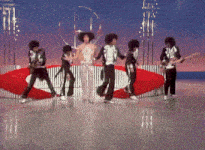 a group of people are dancing on a stage in front of a sign that says ' a ' on it
