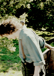 a man in a blue shirt is leaning over a railing