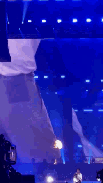 a man is standing on a stage with a flame coming out of his butt .