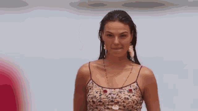 a woman in a purple dress is smiling at a man in a red shirt on the beach .
