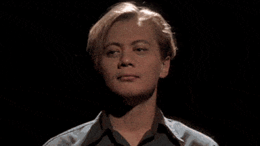 a close up of a young man 's face looking at the camera