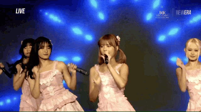 a group of girls singing on a stage with the words live on the bottom