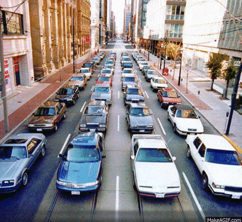 a row of cars are lined up on a city street and one of them has a license plate that starts with the letter b