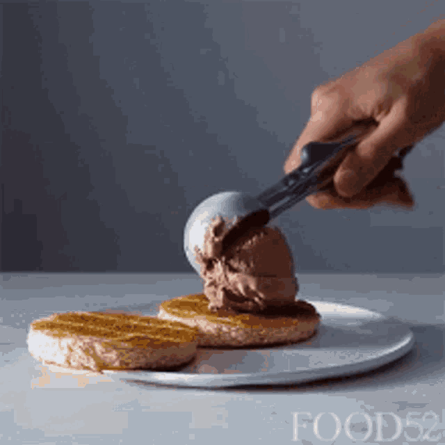 a person is scooping ice cream onto a waffle on a plate