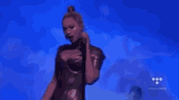 a woman is singing into a microphone on a stage .