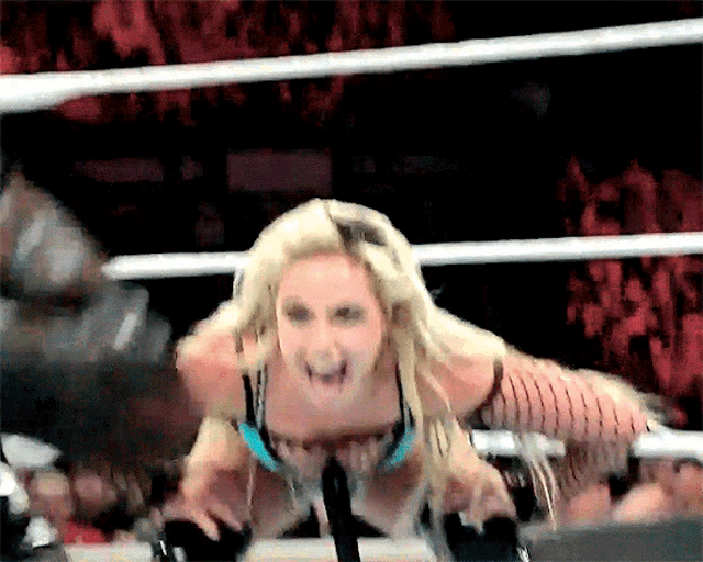 a woman in a wrestling ring with a crowd watching