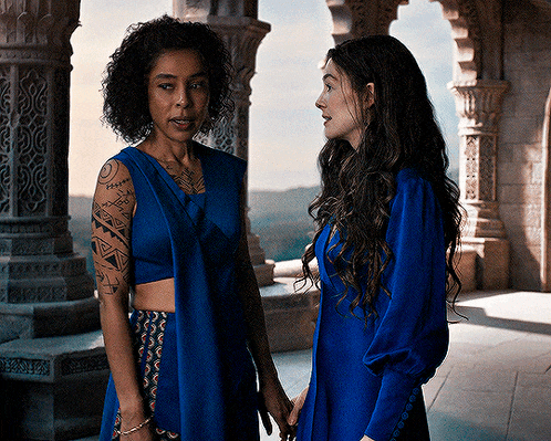 two women are standing next to each other and one has a tattoo on her arm