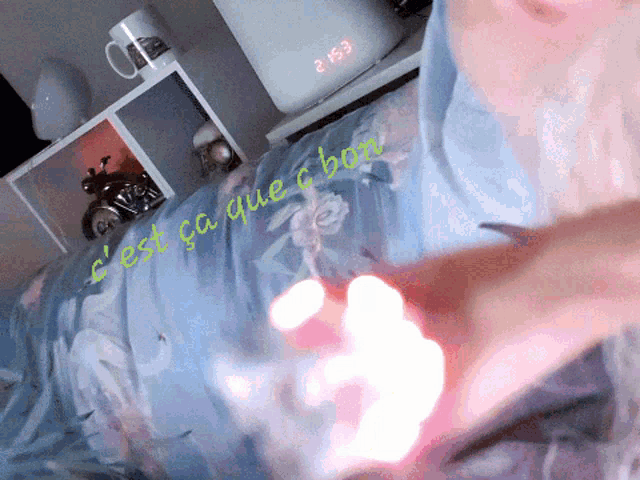a person laying on a bed with a clock displaying the time as 2:03