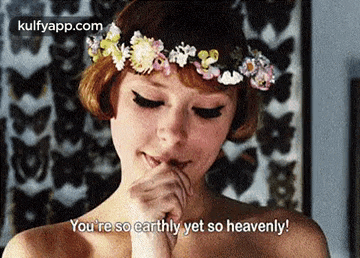 a woman with a flower crown on her head is saying you 're so earthly yet so heavenly .