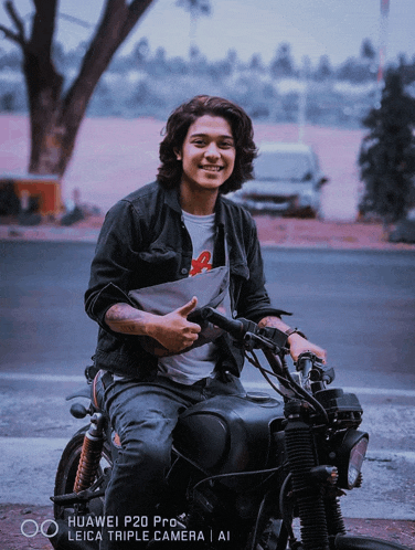 a man riding a motorcycle with a leica triple camera