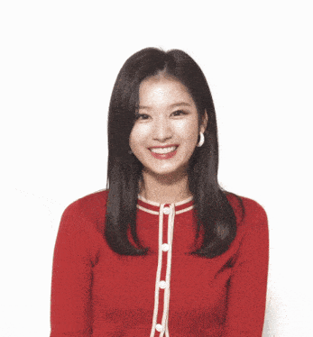 a woman wearing a red sweater with white trim is smiling