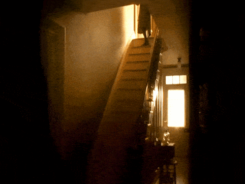a person is walking down a set of stairs in a dark room