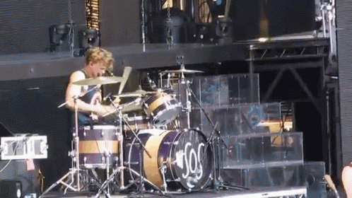a man playing drums in front of a drum set that says ' sos '