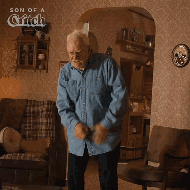 a man in a denim shirt is dancing in a living room with the words son of a grifch on the bottom