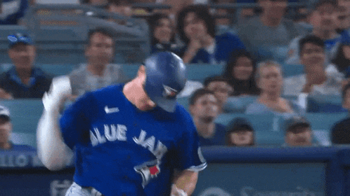 a baseball player for the blue jays swings his bat at a ball