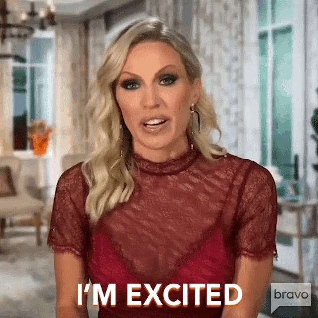 a woman says i 'm excited while wearing a red top