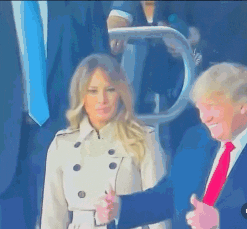 a man in a suit and tie is holding a woman 's hand