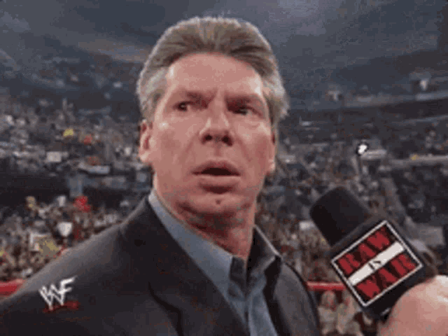 a man in a suit is holding a microphone that says tnt on it