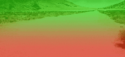a green and red landscape with a tree in the foreground and mountains in the background .