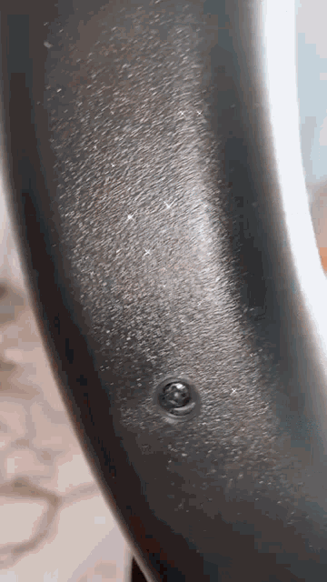 a close up of a screw on a black object .