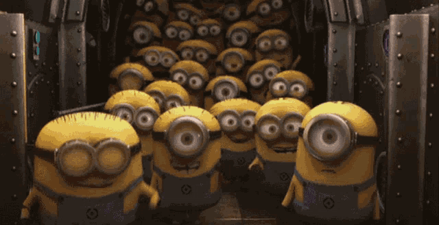 a bunch of minions are standing in front of a metal wall