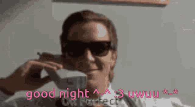 a man wearing sunglasses is holding a stack of money in his mouth and says good night