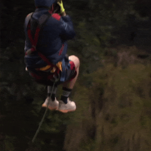 a person is flying through the air with a rope around their waist