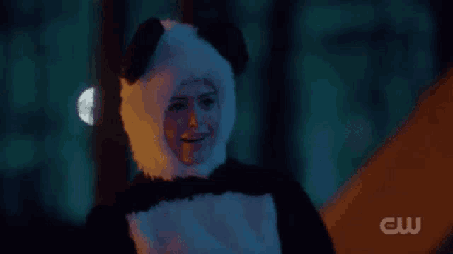 a woman is wearing a panda bear costume and smiling .