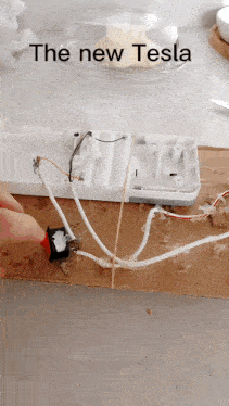 a person is working on a power strip with the words " the new tesla " above it
