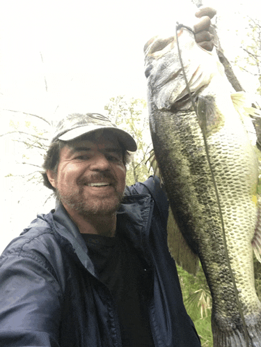 a man holding a large fish in his hands and smiling