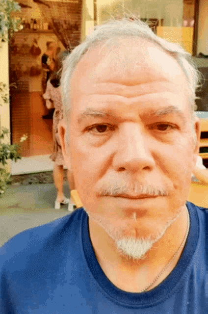 a man with a beard wearing a blue shirt